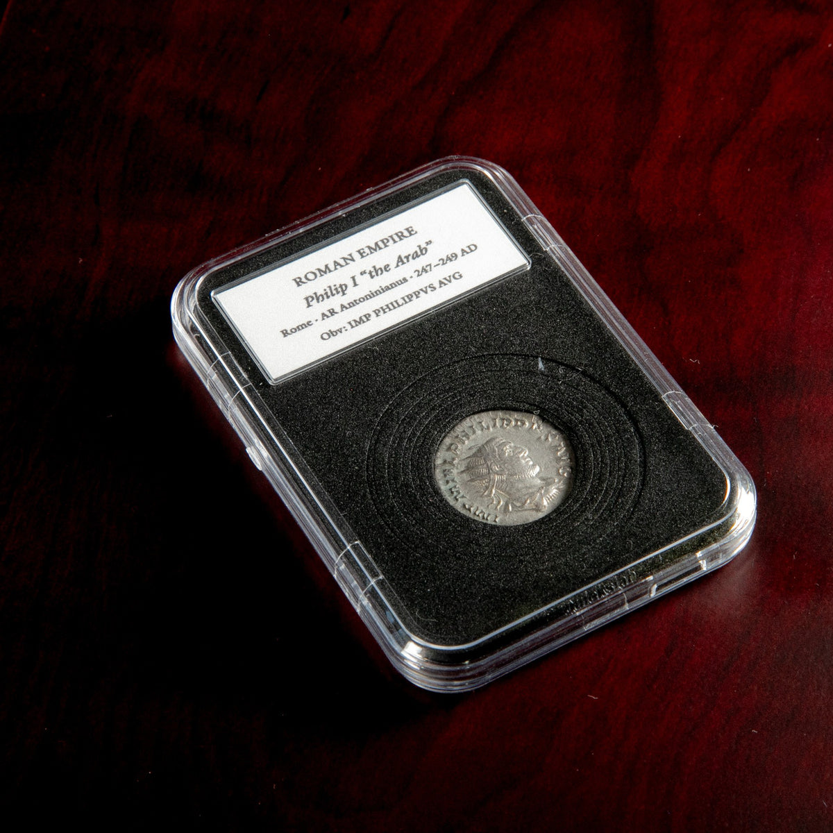 Roman silver antoninianus of Philip I in protective slab with catalog label.