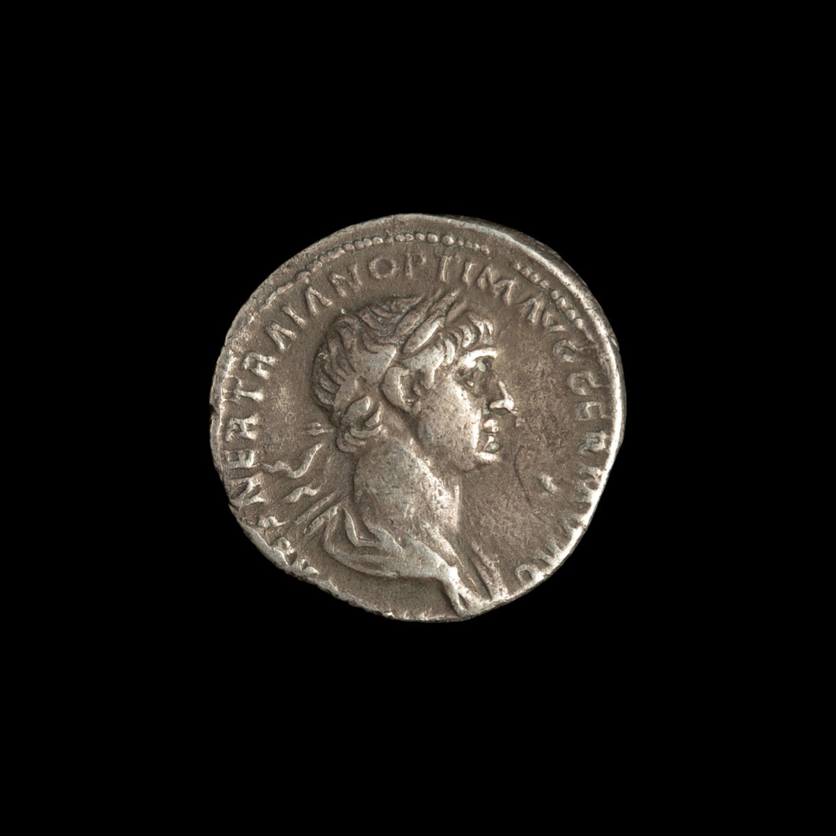Obverse of Roman silver denarius of Trajan, legend IMP CAES NER TRAIAN OPTIM AVG GERM DAC, radiate or laureate bust right.