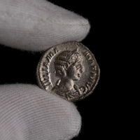 Roman silver denarius of Julia Mamaea held for size reference.