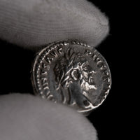 Macro detail of Roman silver denarius of Antoninus Pius, portrait close-up.