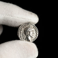 Roman silver denarius of Antoninus Pius shown in hand for context.