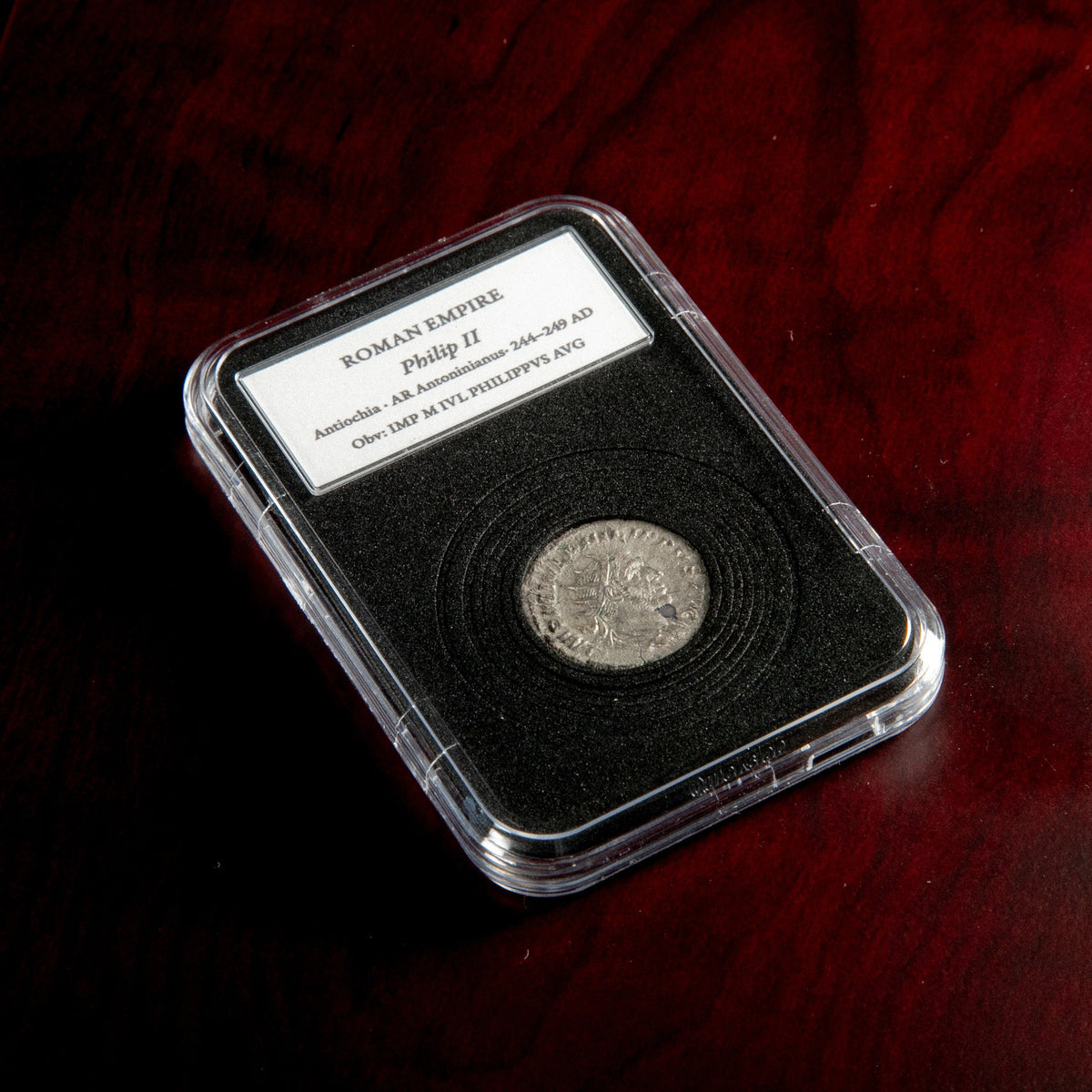 Roman silver antoninianus of Philip II in protective slab with catalog label.