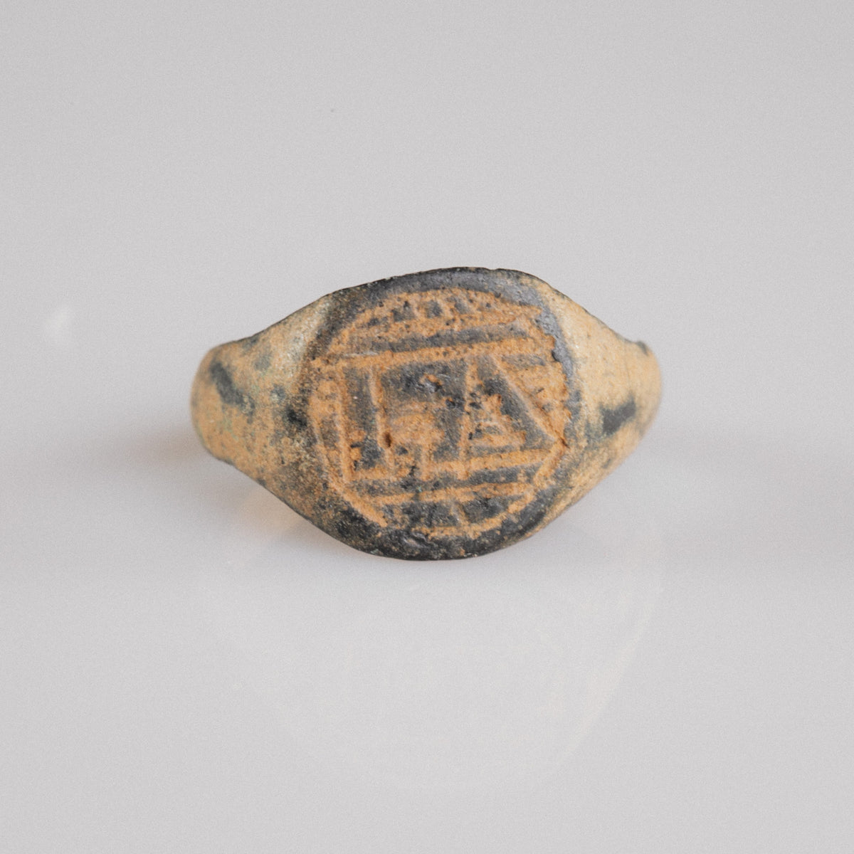 Medieval bronze signet ring Falco, front view of engraved monogram bezel with geometric borders