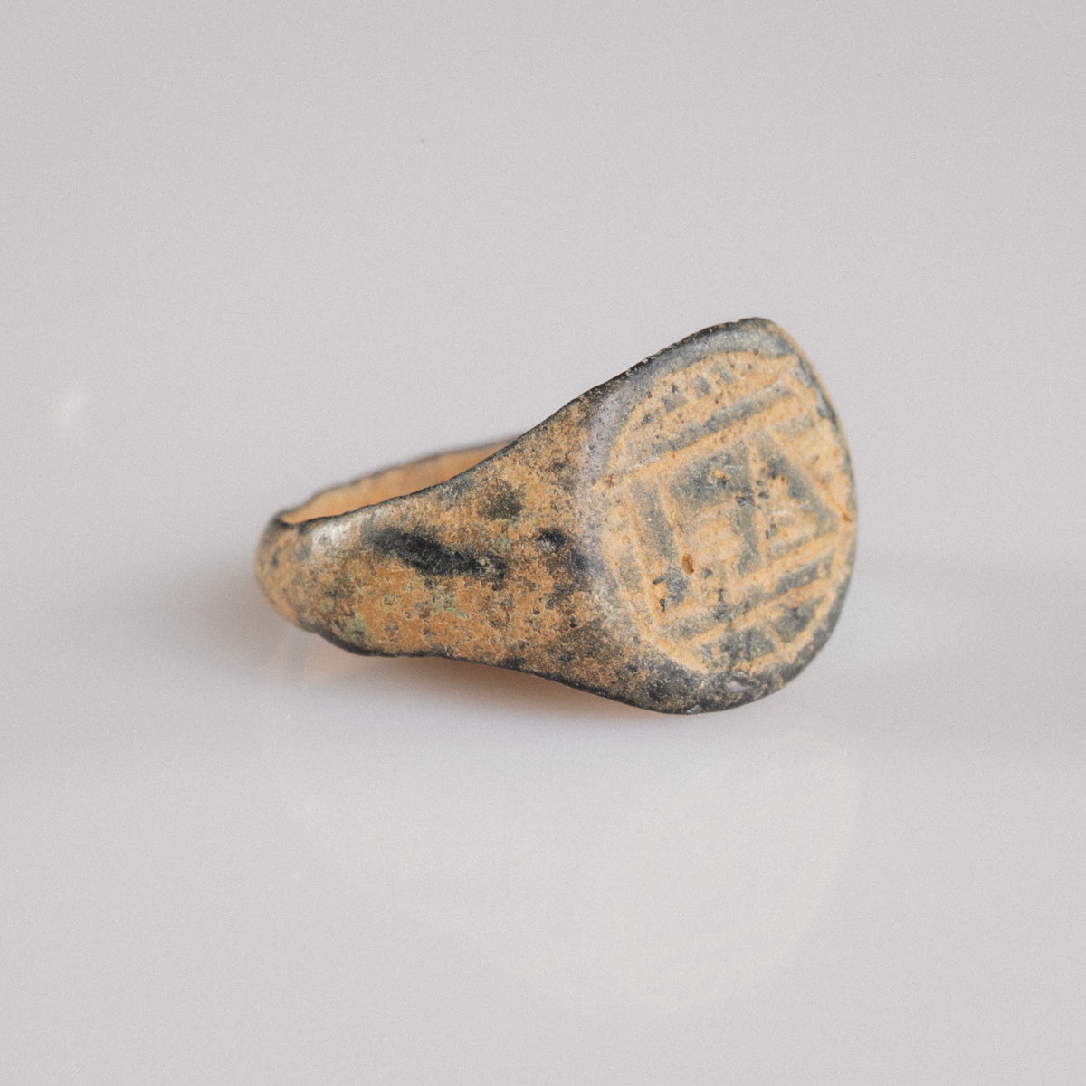 Medieval bronze signet ring Falco, three-quarter view showing flaring shoulder and patina