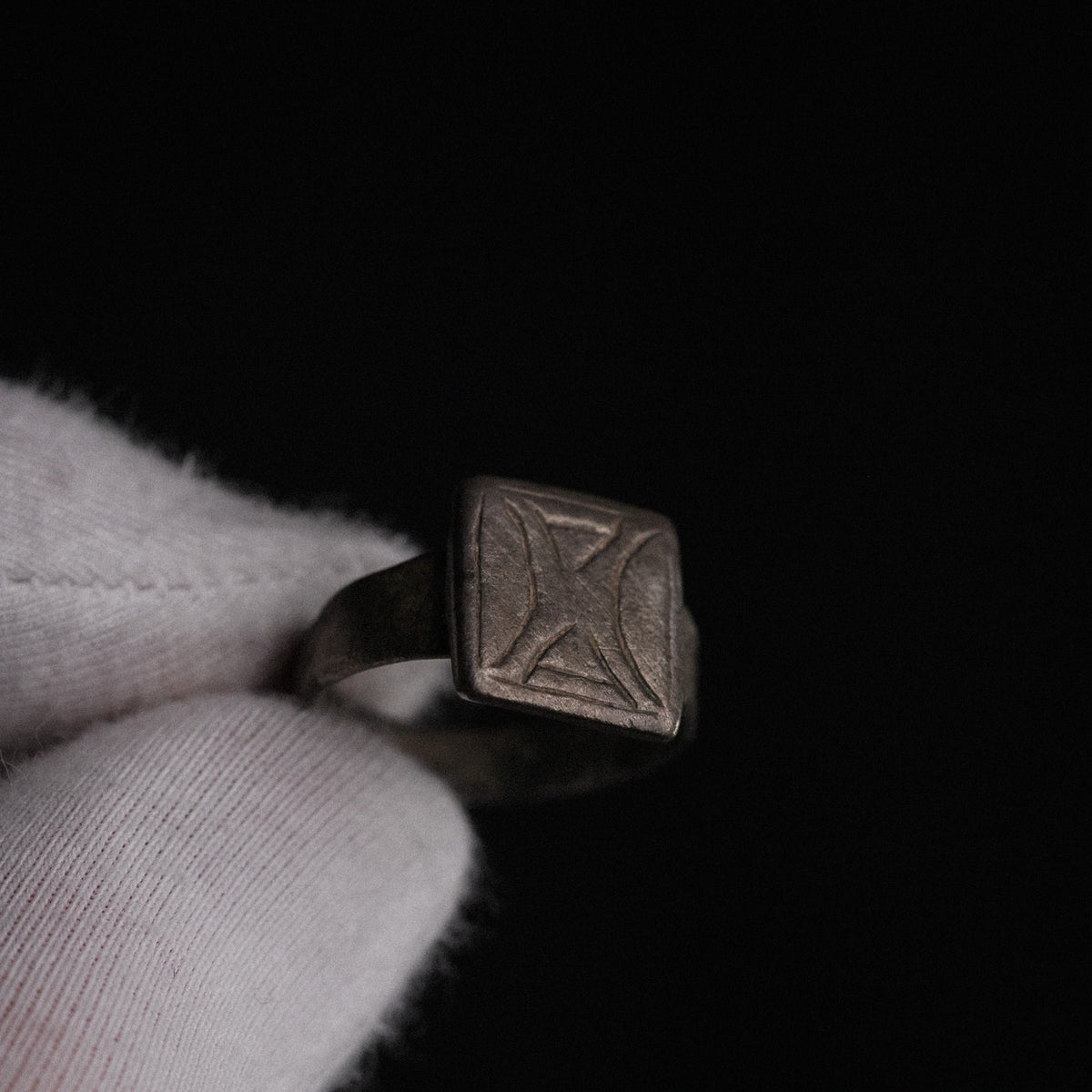 Dramatic low-light study of Byzantine silver ring Theofanis highlighting bezel engraving