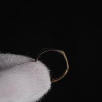 Medieval bronze signet ring Falco held in gloved hand, back view showing hoop taper and patina