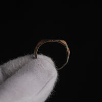 Medieval bronze ring Aldren held in gloved hand, profile view showing slender hoop and patina