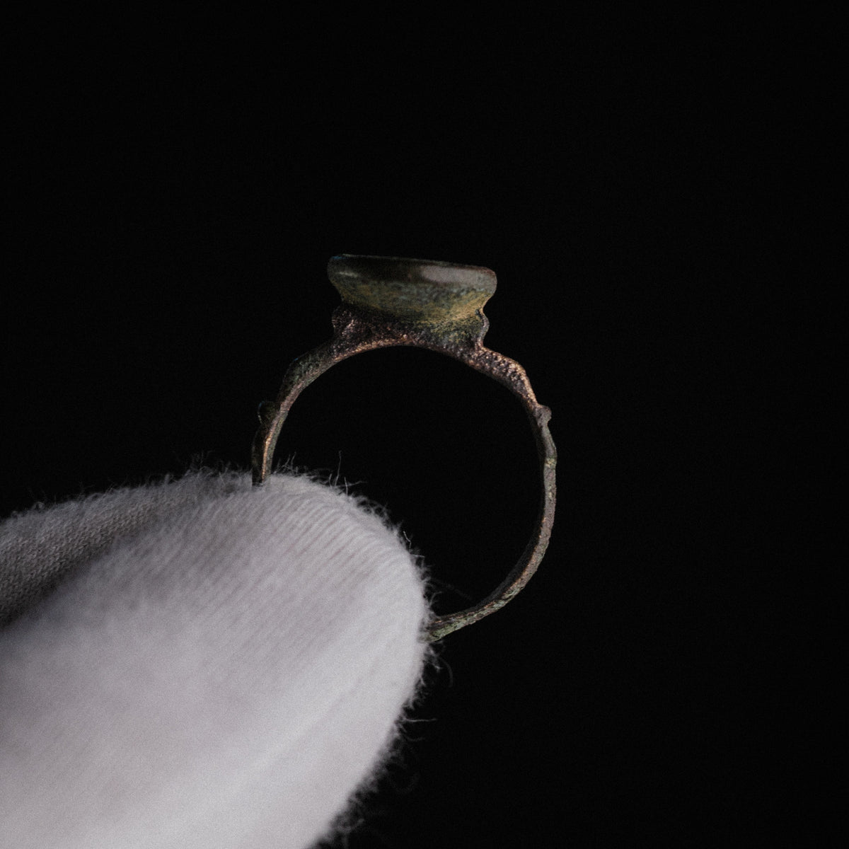 Profile view of Islamic bronze ring Zahir showing raised bezel neck and stepped shoulder ridges