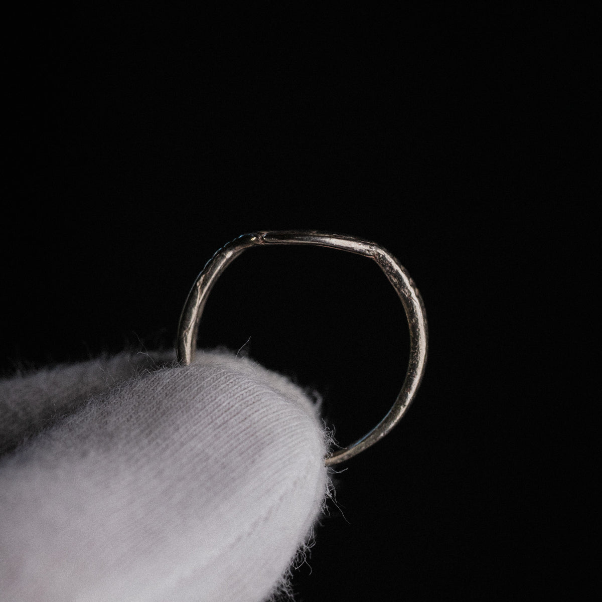 Side profile of medieval silver ring Lysenne revealing D-section hoop and tapering shoulders