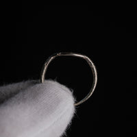 Side profile of medieval silver ring Lysenne revealing D-section hoop and tapering shoulders