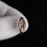 Close-up of Roman silver ring Faunus bezel with engraved striding satyr figure