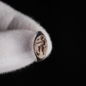 Close-up of Roman silver ring Faunus bezel with engraved striding satyr figure
