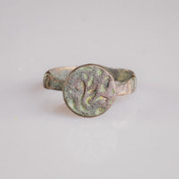 Studio view of Islamic bronze signet ring Zahir displaying flat circular bezel and tapering hoop