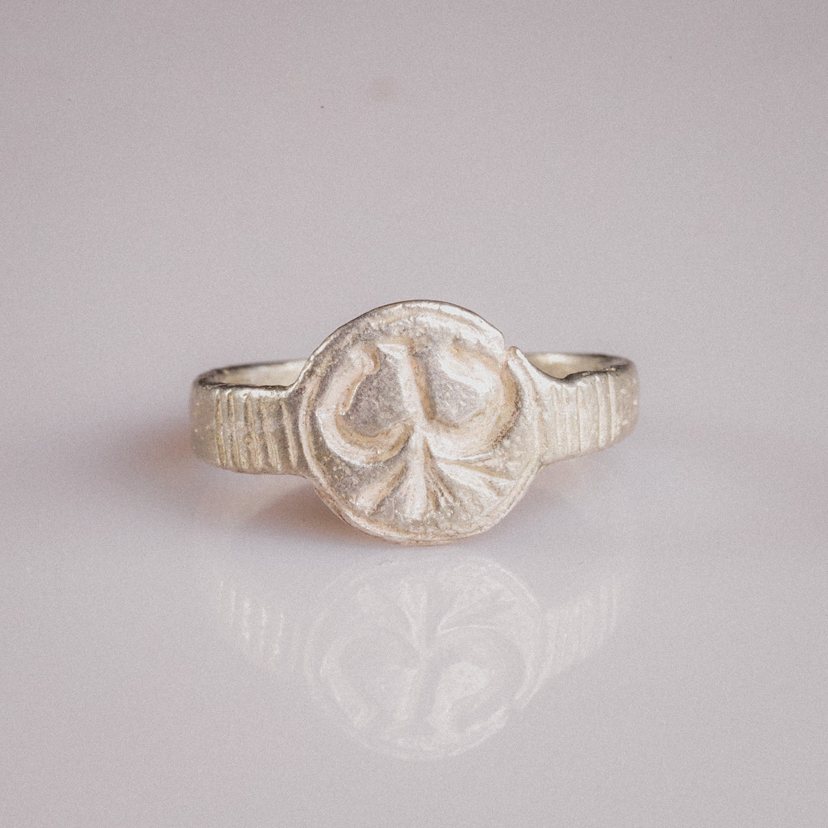 Front view of medieval silver ring Lysenne with ribbed shoulders and heraldic bezel
