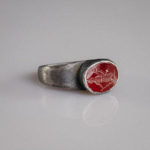 Roman silver ring Sereia three-quarter view showing raised oval garnet bezel and engraved figure