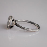 Angled view of Byzantine silver ring Crucia with slender wire hoop and disc bezel