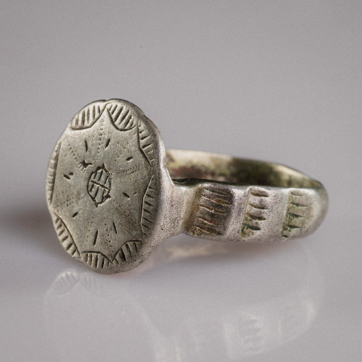 Three-quarter view of medieval silver ring Stavros highlighting cross bezel and shoulder hatching