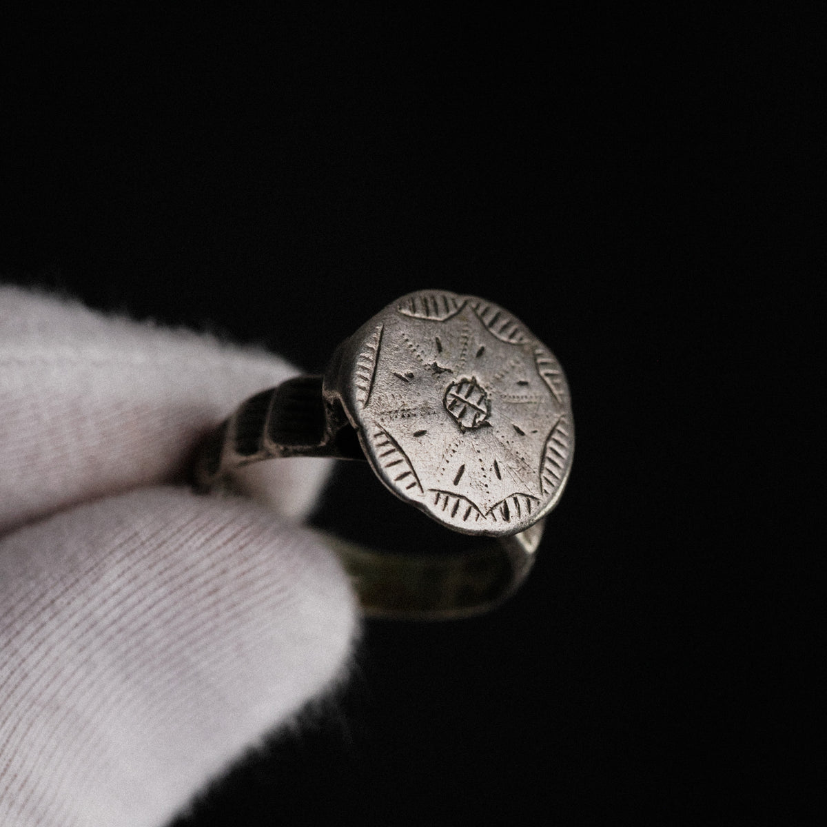 Close-up of medieval silver ring Stavros showing crisp cross-in-circle engraving in hand
