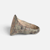 Medieval Islamic bronze ring 'Tahir' shows its broad shoulder and bezel edge from the side.