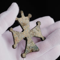 Angled close-up of Medieval bronze cross 'Gemmata' showing patina across the plate and knob ends.