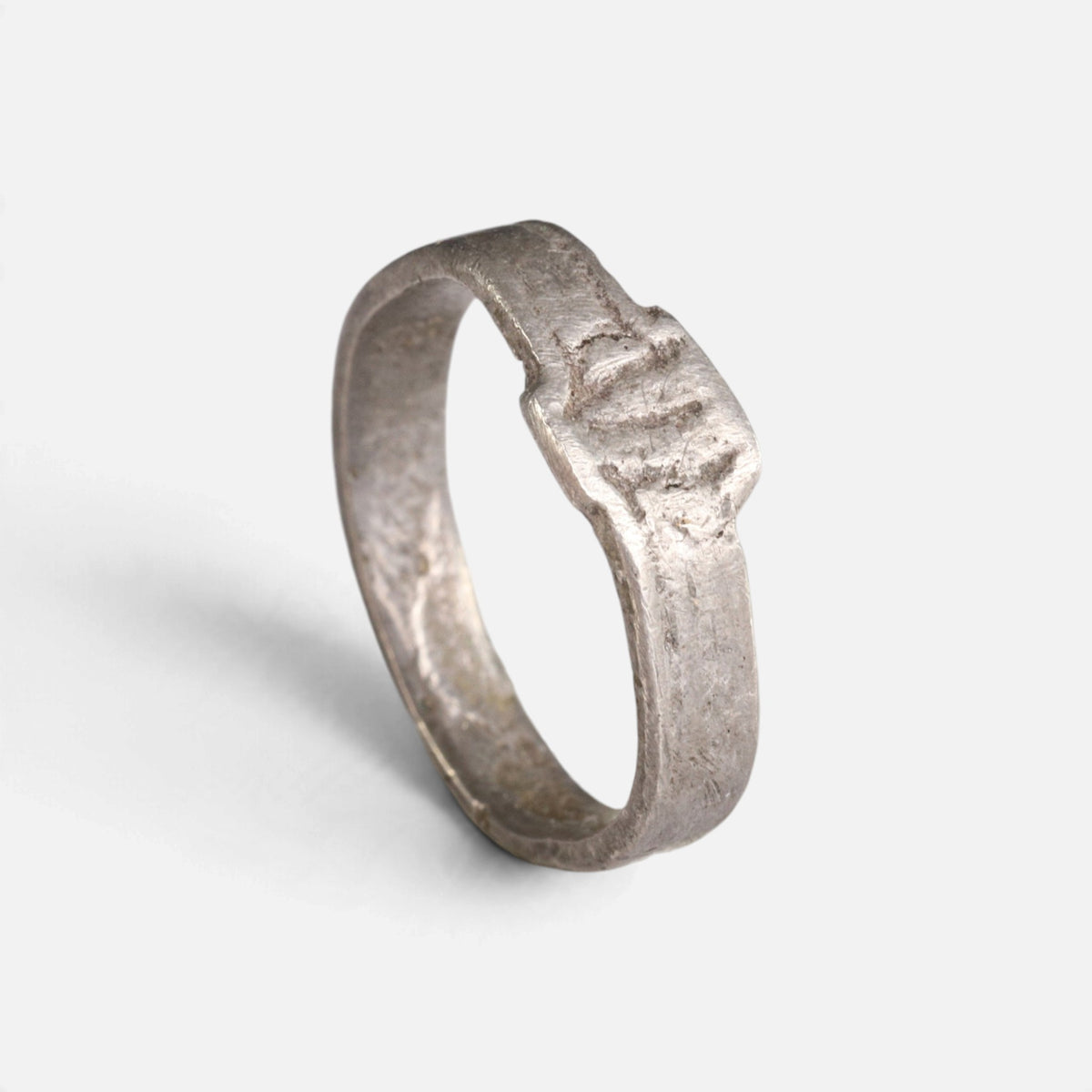 Roman silver ring 'Sextus' shows its small incised bezel and flat band at an angle.