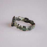 Angled profile of medieval bronze ring Quintus with cuprite red and malachite green patina