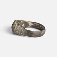 Medieval bronze ring 'Radwina' shows its engraved shoulder and raised setting from the opposite side.