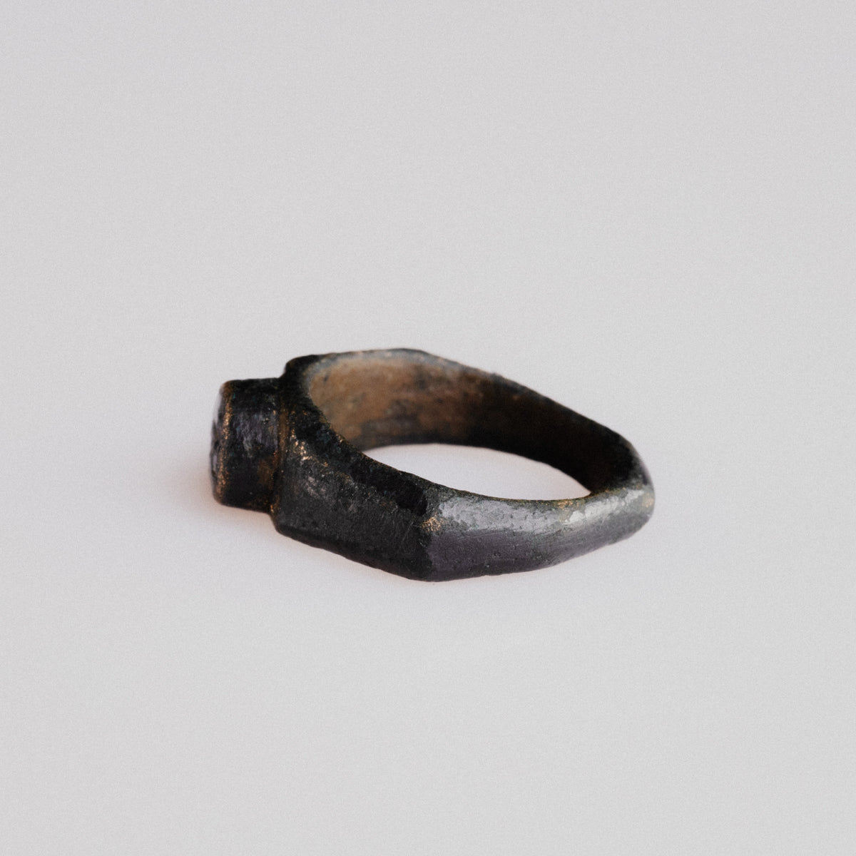 Angled side view of Roman bronze ring Numerius with integral cast bezel