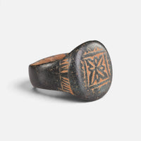 Byzantine bronze ring 'Kallisto' shows its framed bezel device and engraved shoulder at an angle.