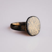Angled view of Byzantine bronze ring Stellaris highlighting patina and bezel iconography