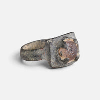 Medieval bronze ring 'Aldonza' shows its raised reddish setting and broad shoulder at an angle.