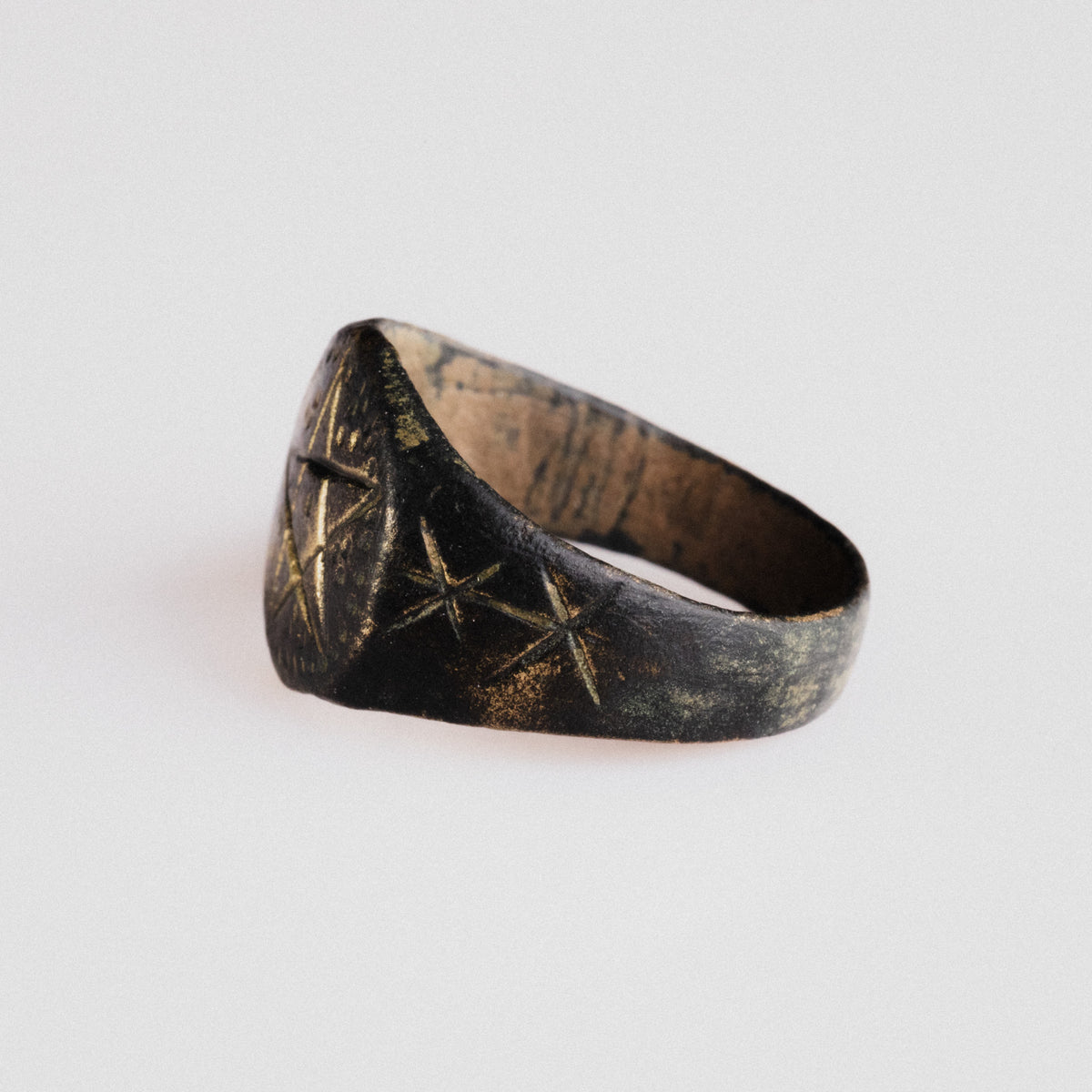 Angled view of medieval bronze ring Astariel highlighting shoulder star engravings
