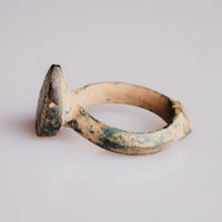 Angled view of medieval bronze ring Zvezdan showing bezel elevation and hoop shoulder