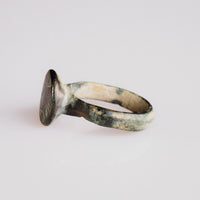 Angled view of medieval bronze signet ring 'Aldric' showing bezel engraving and shoulder flare