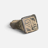 Medieval Islamic bronze ring 'Rashida' shows its rectangular bezel engraving and broad shoulder at an angle.
