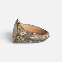 Medieval Islamic bronze ring 'Nasirun' shows its decorated shoulder and bezel edge from the side.