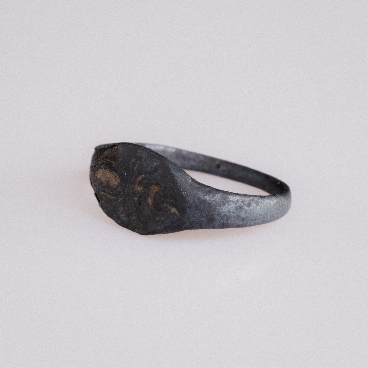 Angled view of Roman bronze ring Formica highlighting ant engraving and shoulder wear