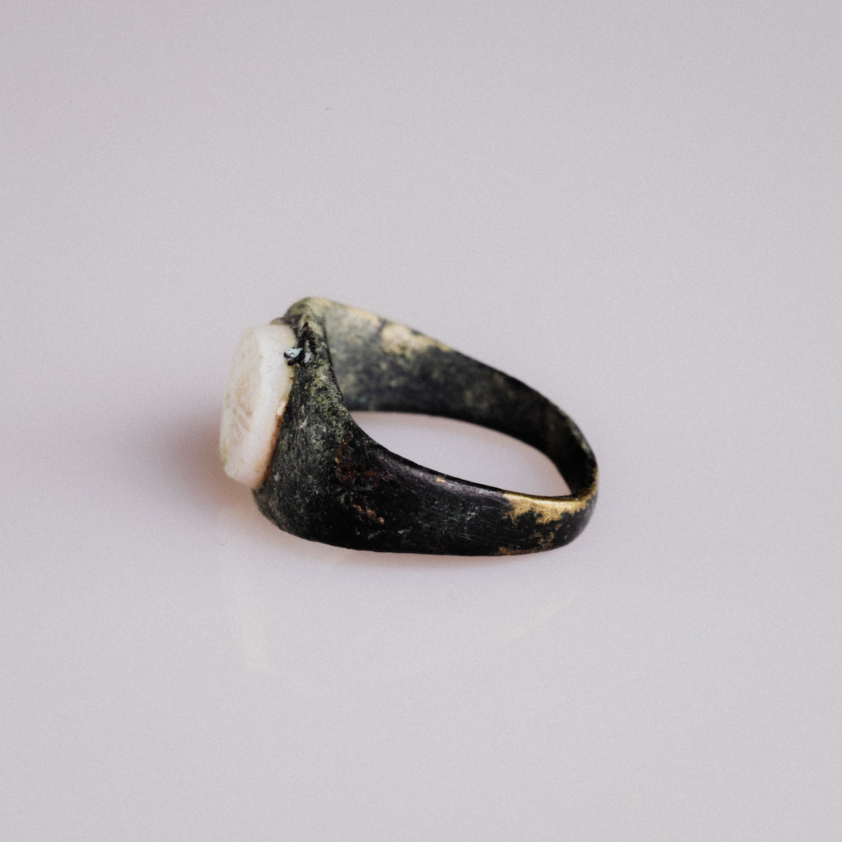 Angled view of Roman bronze ring Numerius with visible malachite and tenorite patina