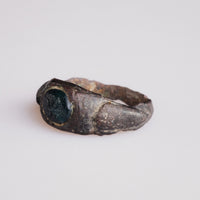 Angled view of Roman bronze ring Volusenus with visible shoulder wear and glass intaglio