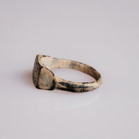 Angled view of Roman bronze signet ring Grypho with malachite green patina on shoulder