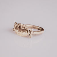 Angled view of Roman silver signet ring Numeria highlighting the intaglio drapery hatching on the bezel