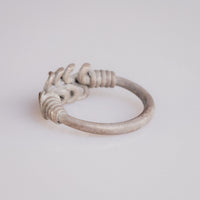 Roman silver wire ring 'Nodus' shows its plain hoop and wound shoulders from behind at an angle.