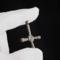 Byzantine bronze cross pendant Chariton held in a gloved hand for scale, showing devotional pectoral size