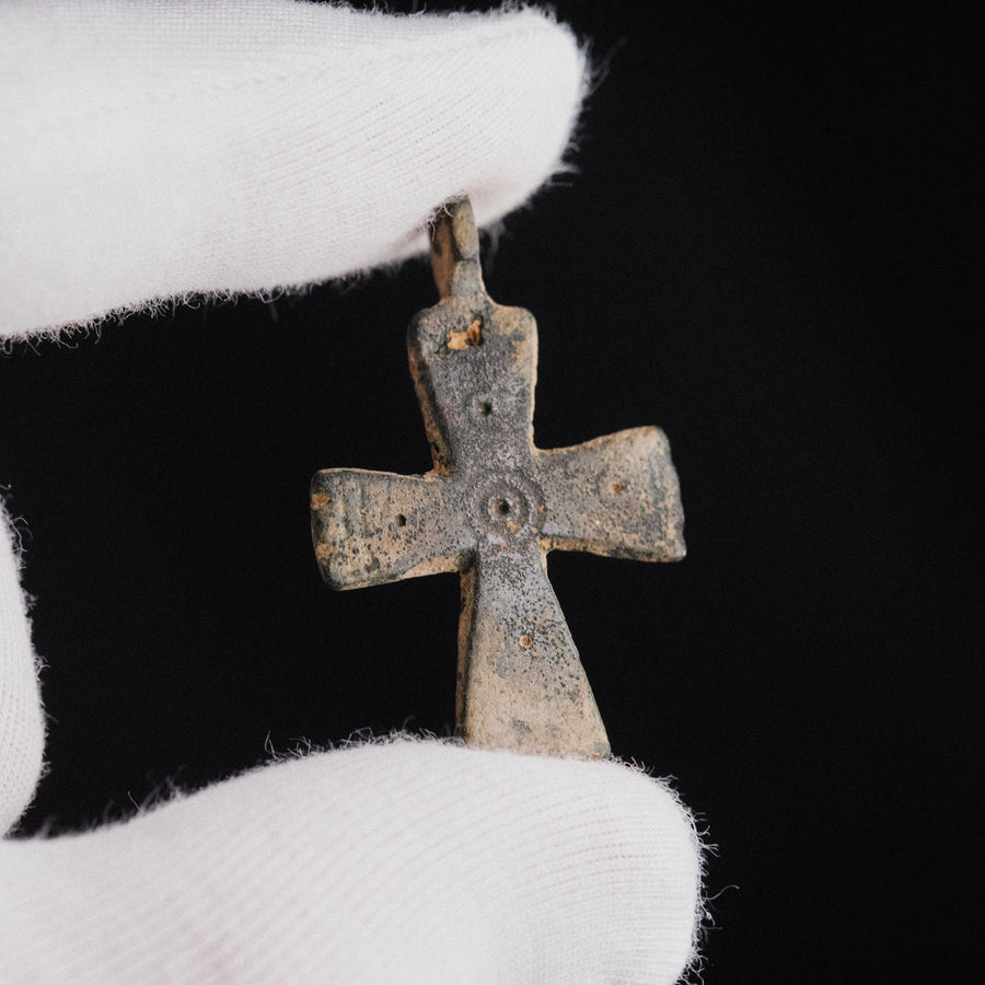 Byzantine bronze cross pendant Phanourios held in gloved hand, showing scale and punched decoration