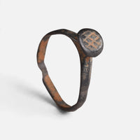 Byzantine bronze ring 'Georgios' shows crossed strokes on its small round bezel and complete hoop at an angle.