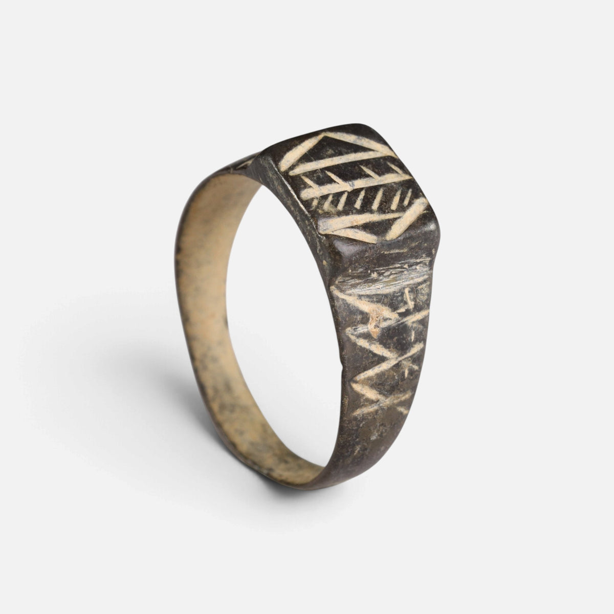 Byzantine bronze ring 'Ioanna' shows its incised bezel design and full broad hoop at an angle.