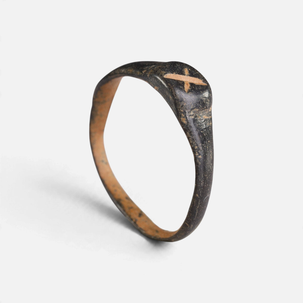 Byzantine bronze ring 'Isidoros' shows its small X-shaped mark and complete hoop at a higher angle.