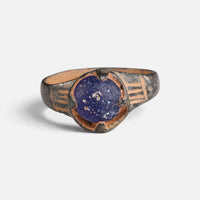 Byzantine bronze ring 'Kallinike' shows its blue setting and incised shoulder grooves from the front.