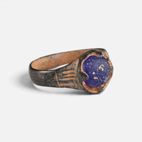 Byzantine bronze ring 'Kallinike' shows its blue setting and grooved broad shoulder at an angle.