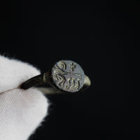 Byzantine bronze ring Mikhael held in gloved hand, close-up of engraved bezel